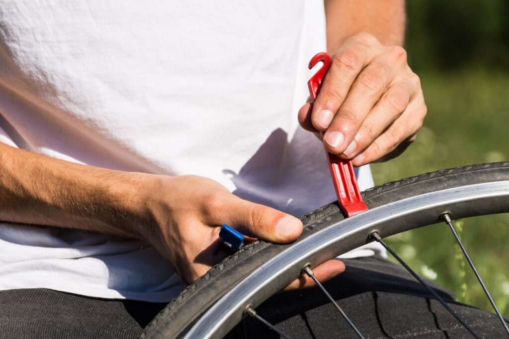 man using tool to remove damaged inner tube