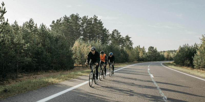 3 cyclists enjoying a scenic bike ride trip.