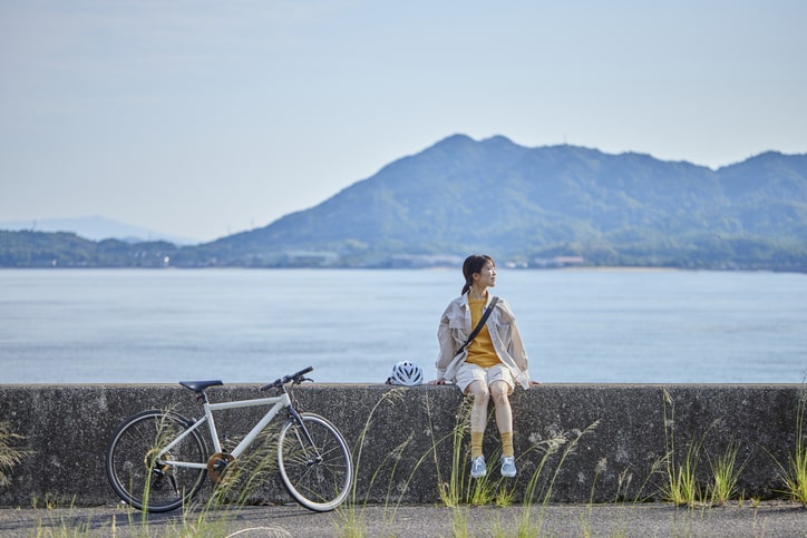Young woman enjoying the view while on a break mid bike ride.